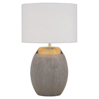 Table lamp with a textured gray base and white shade on a white background