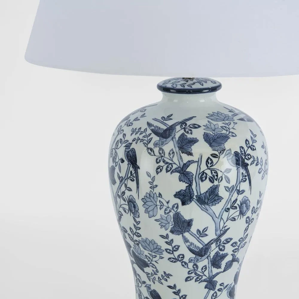 White lamp with blue floral and bird pattern on a white background