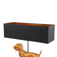 Black rectangular lampshade on a white background with a gold dog sculpture.