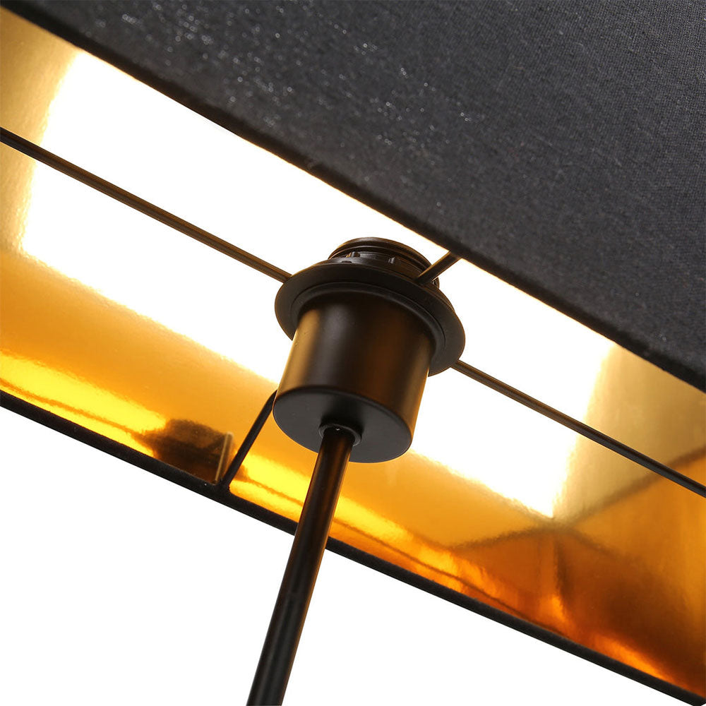 Close-up of a lamp with a black shade and gold interior
