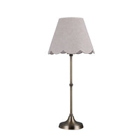 Table lamp with a scalloped gray shade on a white background
