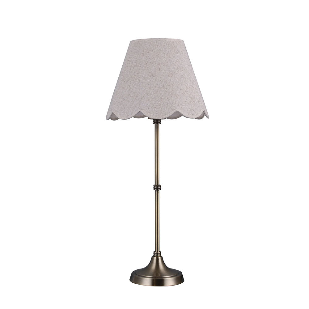 Table lamp with a scalloped gray shade on a white background
