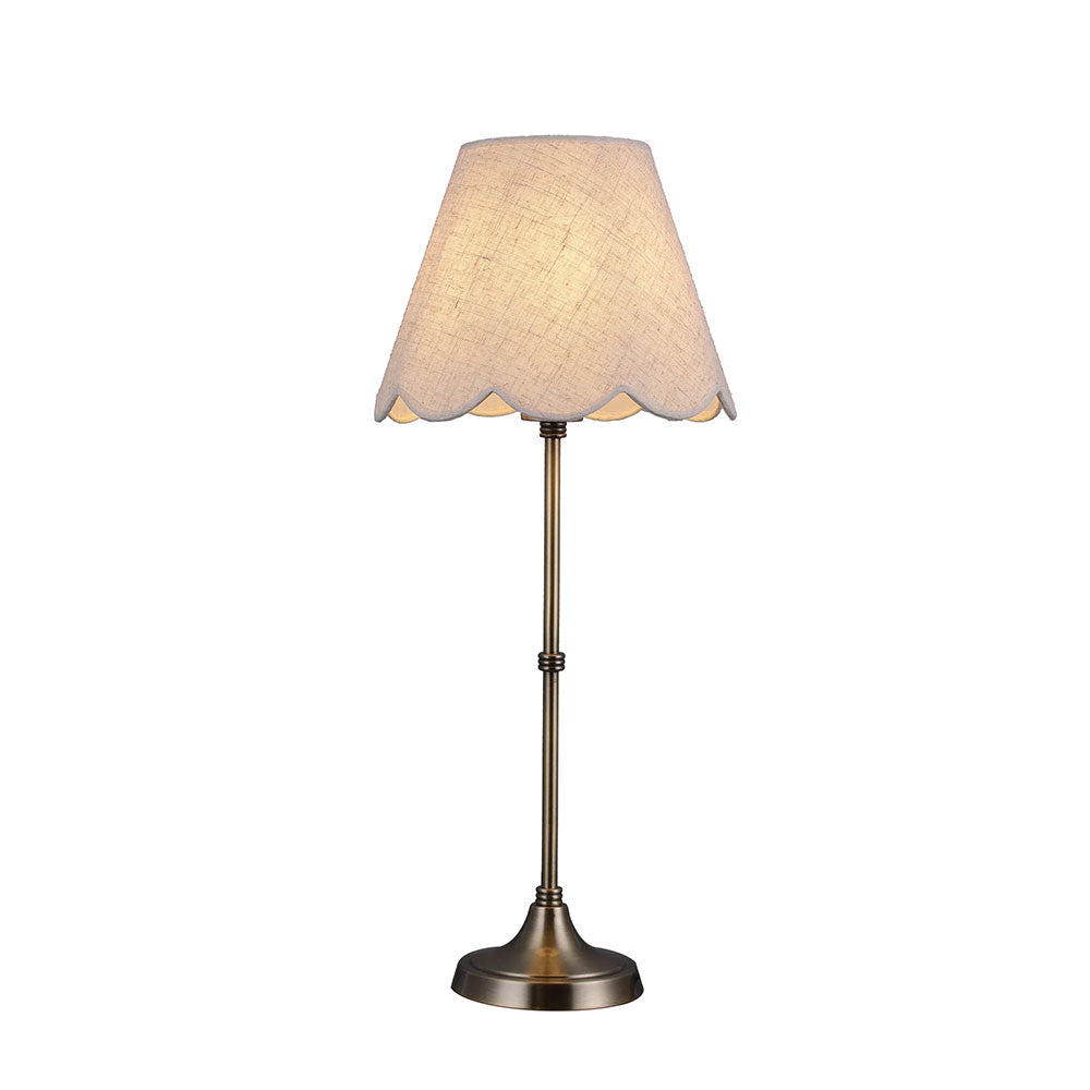 Table lamp with scalloped lampshade on a white background