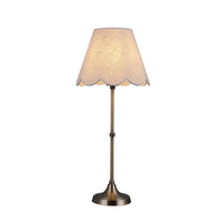 Table lamp with scalloped lampshade on a white background