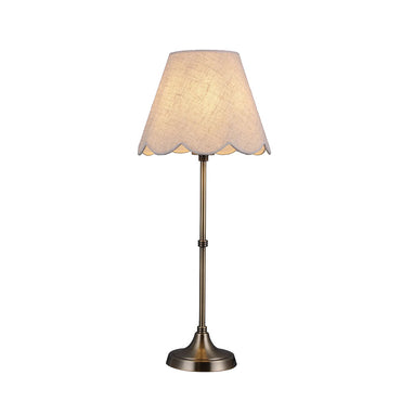 Table lamp with scalloped lampshade on a white background