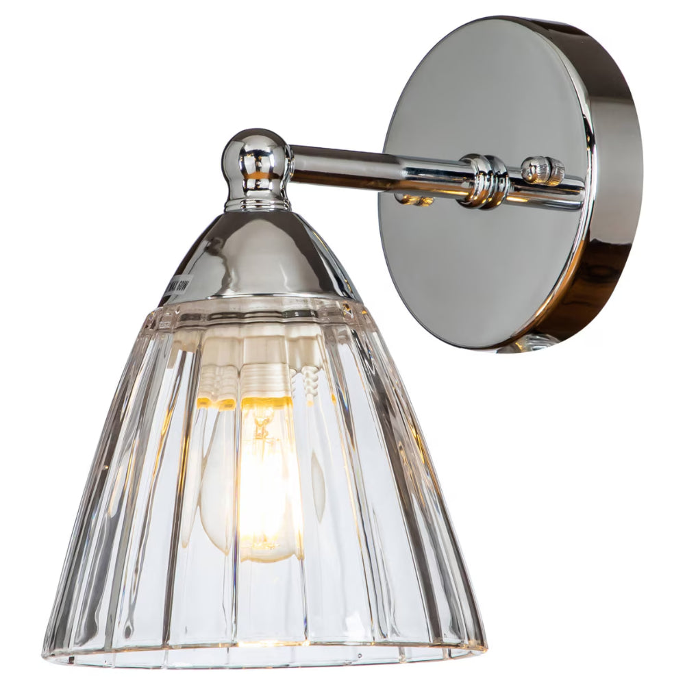 Wall-mounted light fixture with clear glass shade and chrome finish on a white background