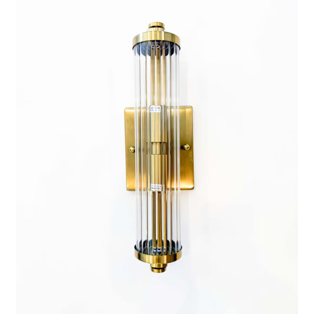 Gold wall sconce with clear glass on a white background