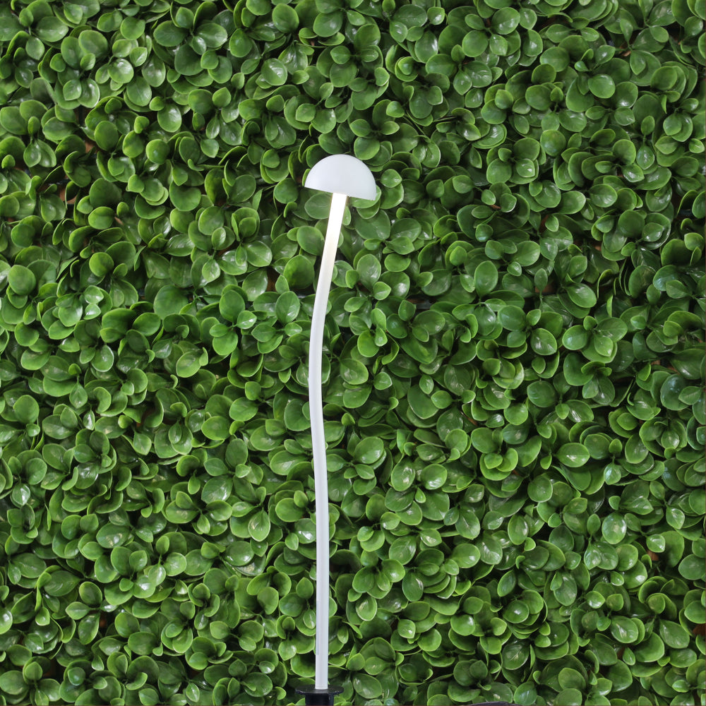White mushroom-shaped light on a green leafy background