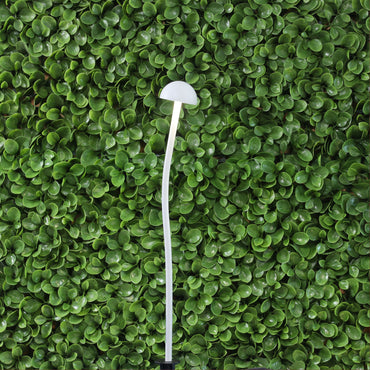 White mushroom-shaped light on a green leafy background