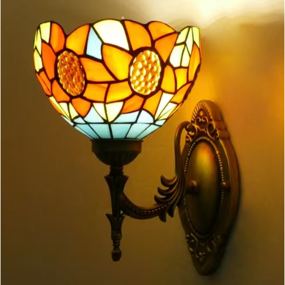 Decorative wall sconce with stained glass design on a beige wall.